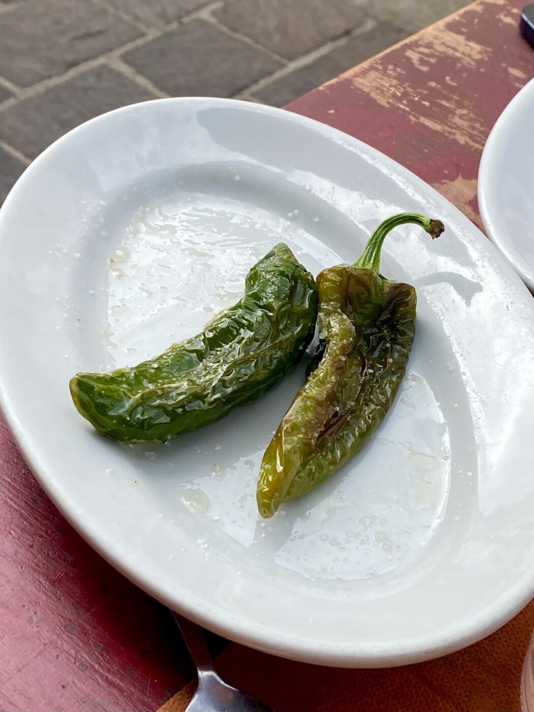 two friggitelli peppers on a white plate