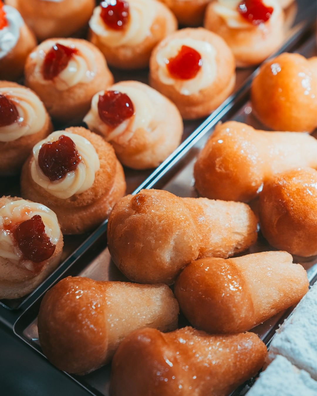 a close up image of babà al rum arranged in a case