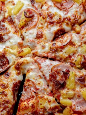 a close up image of a pizza with pineapple on it