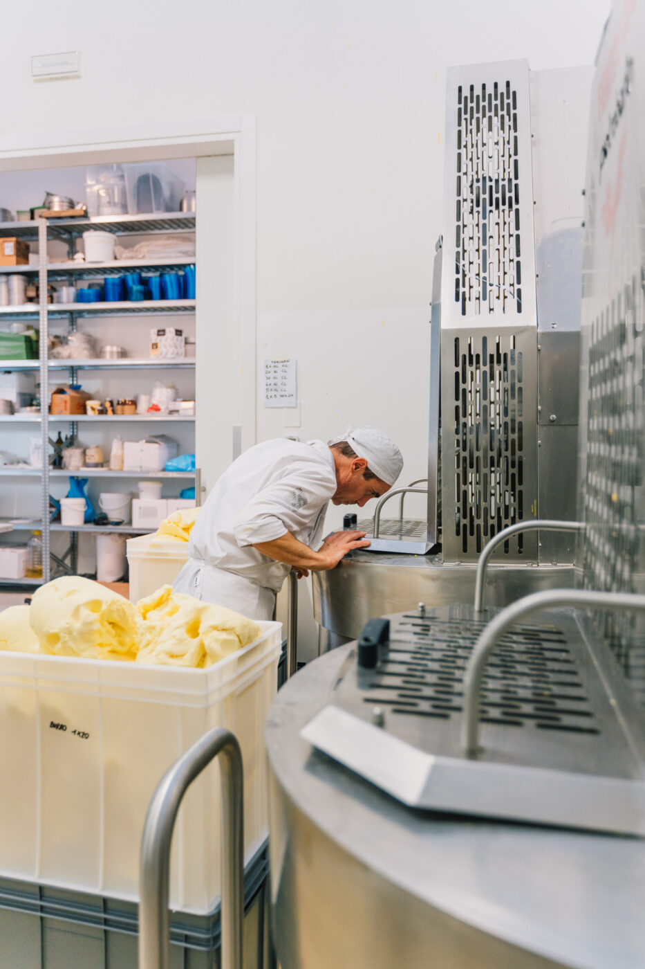 a man looking into a giant mixer and he's making dough for pandoro