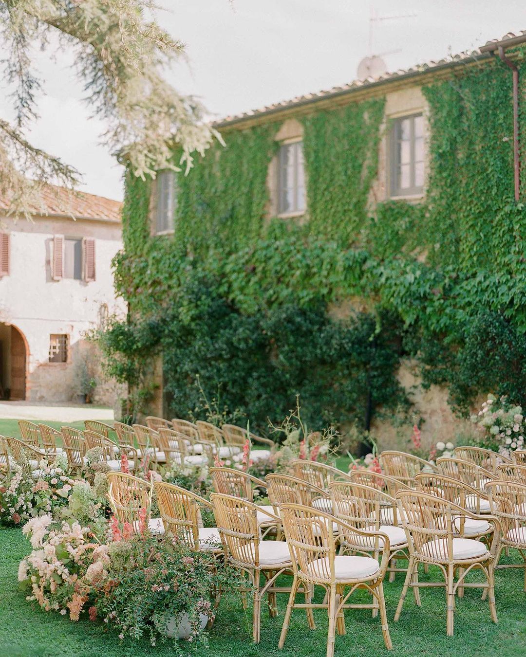 a beautiful set up for a wedding service with chairs, flowers, and an aisle at La Pescaia