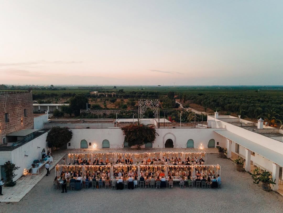 two large imperial tables set up for a wedding reception in the center courtyard of masseria potenti