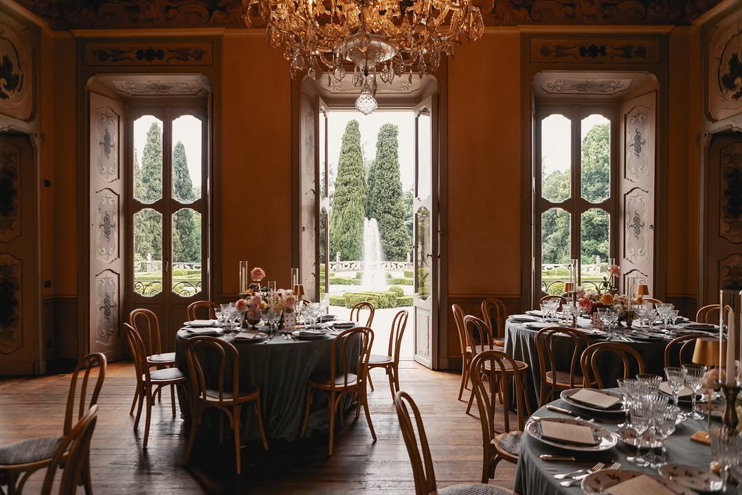 round tables inside a beautiful room looking out onto the gardens of Villa Subaglio