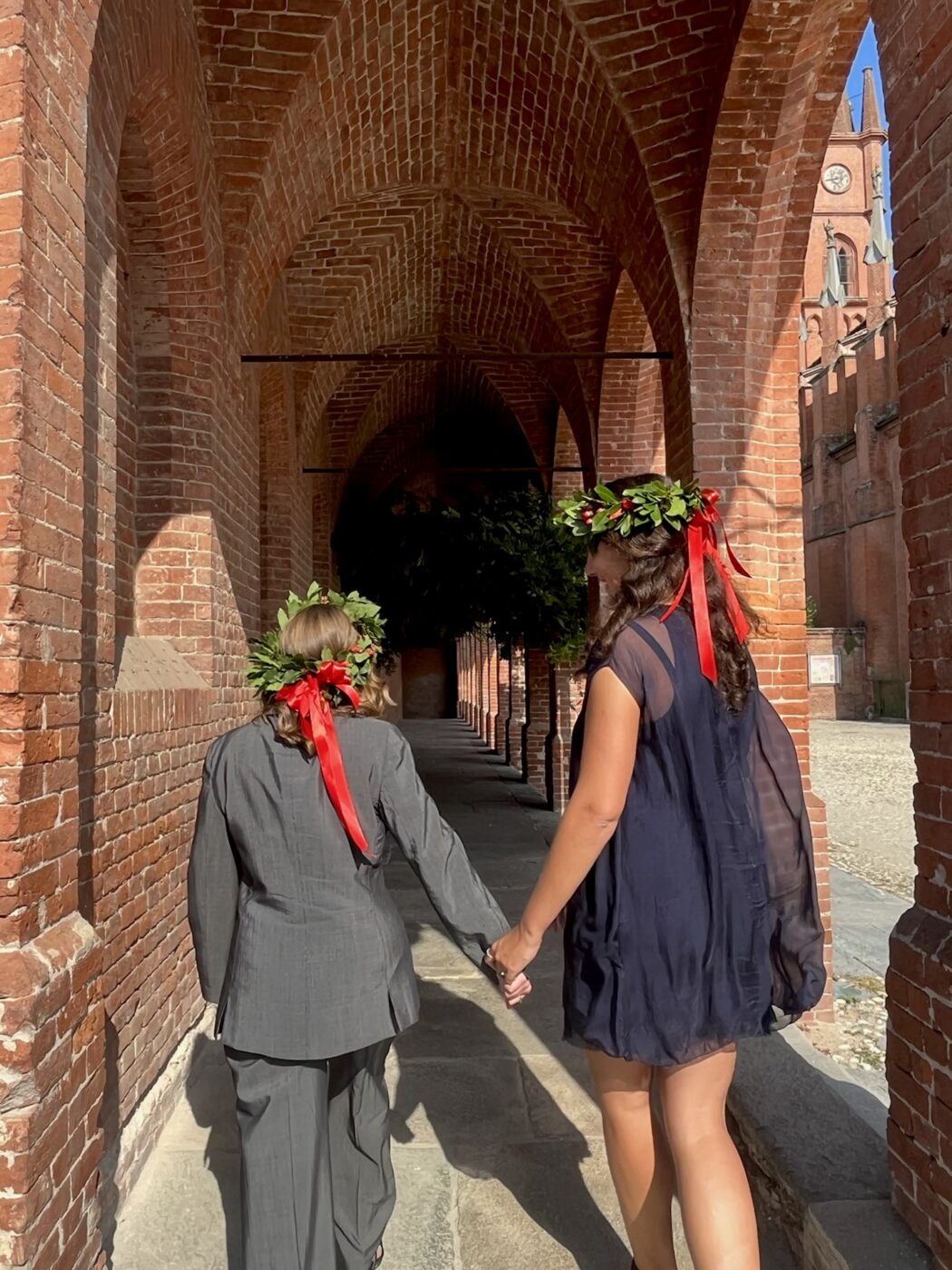 an image of two women walking away wearing laurel crowns at their graduation