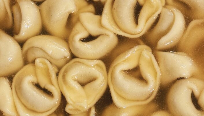a close up image of tortellini in brodo