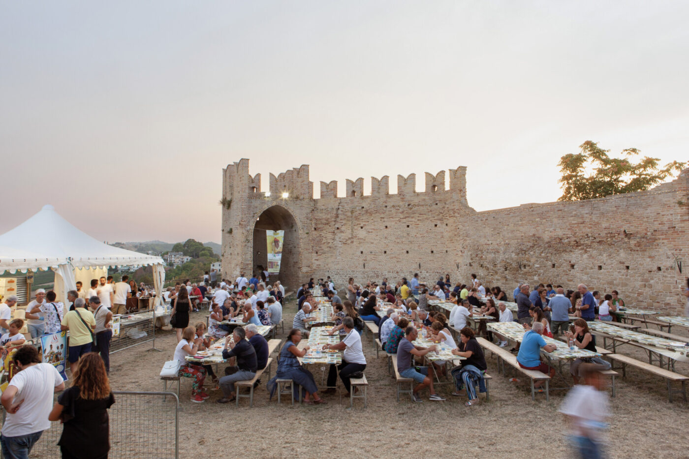 people eating at large picnic tables at the Sagra dei Maccheroncini