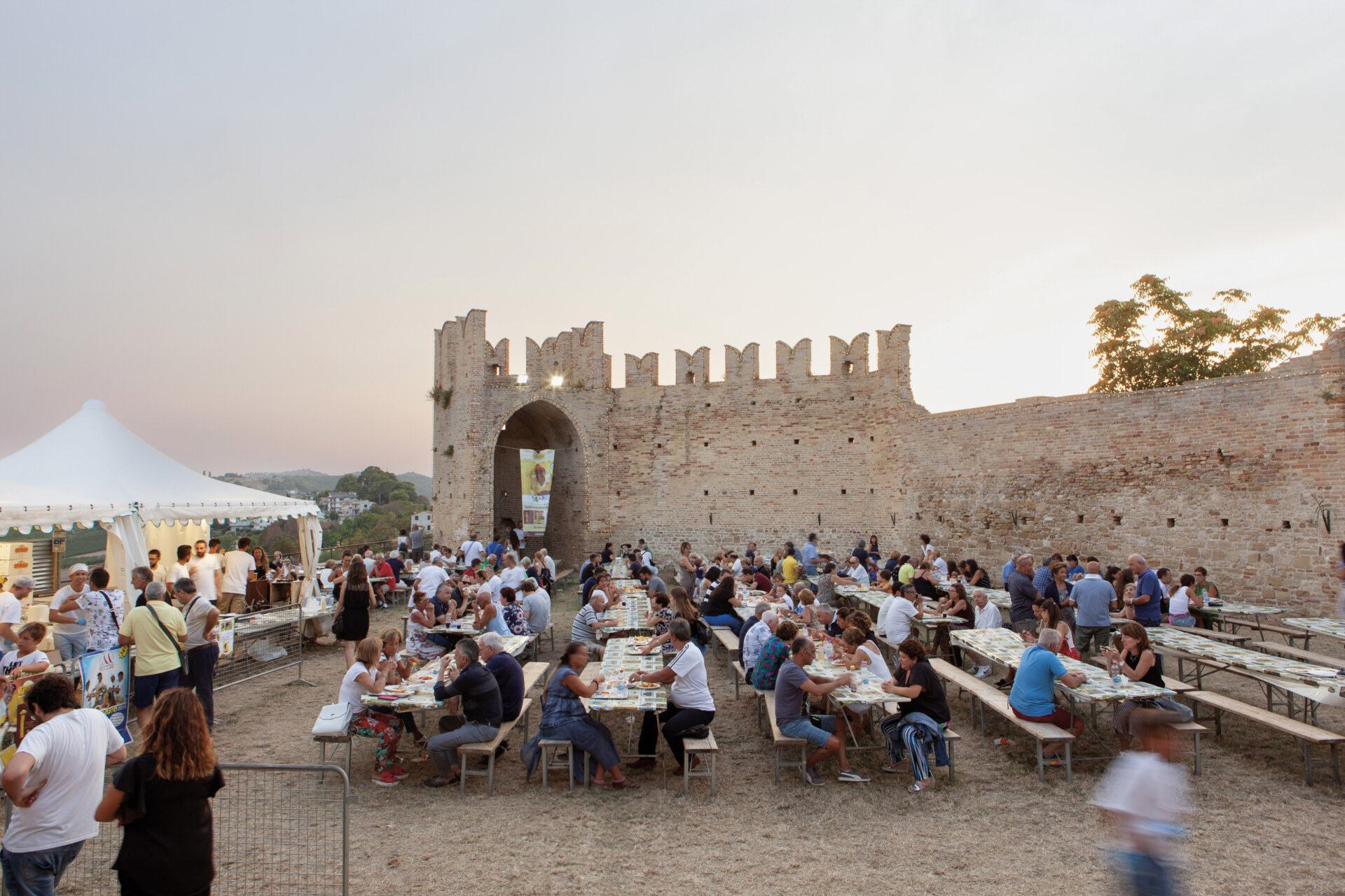 people eating at large picnic tables at the Sagra dei Maccheroncini