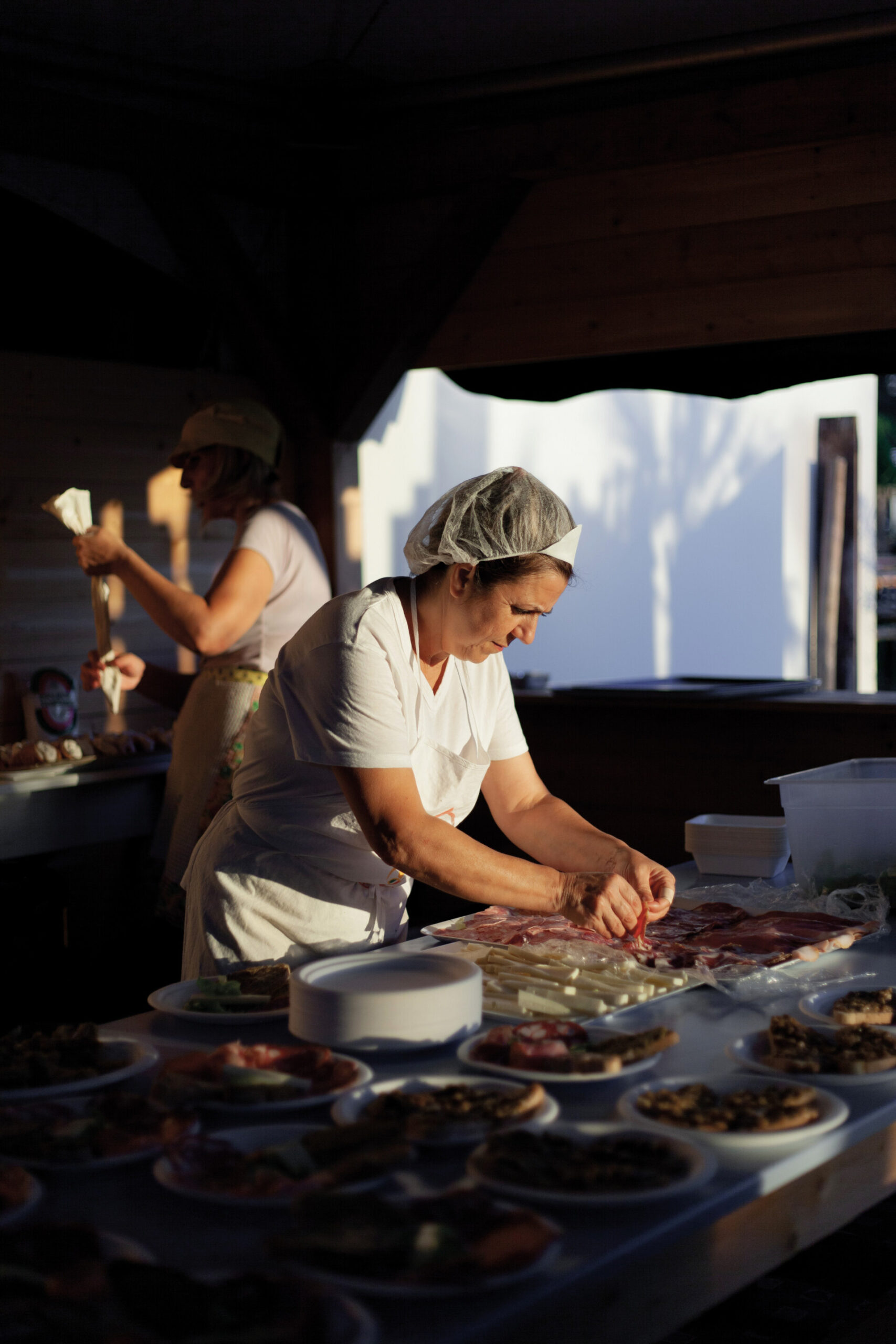 a woman working a booth at the sagra del fungo di bomarzo