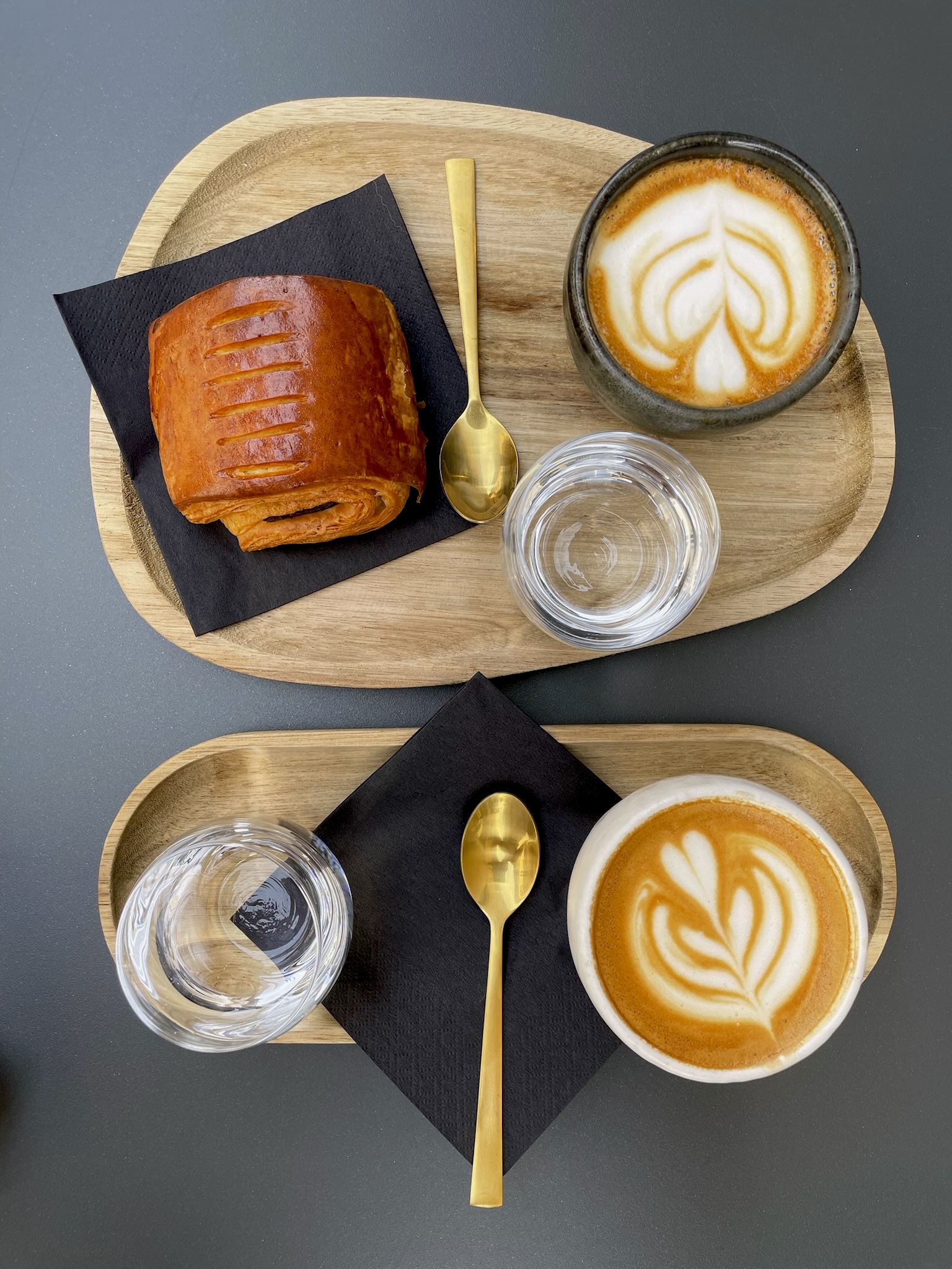 an overhead image of two flat whites with a croissant from Parallels Café in Bra