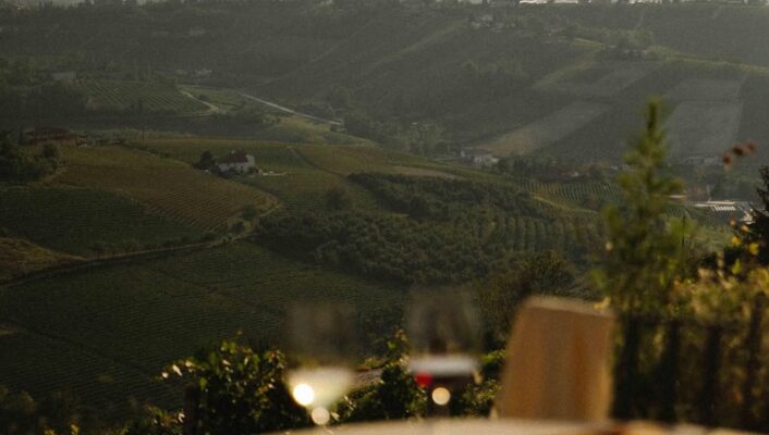 a beautiful table set with wine overlooking the piedmontese hills at dai gresy