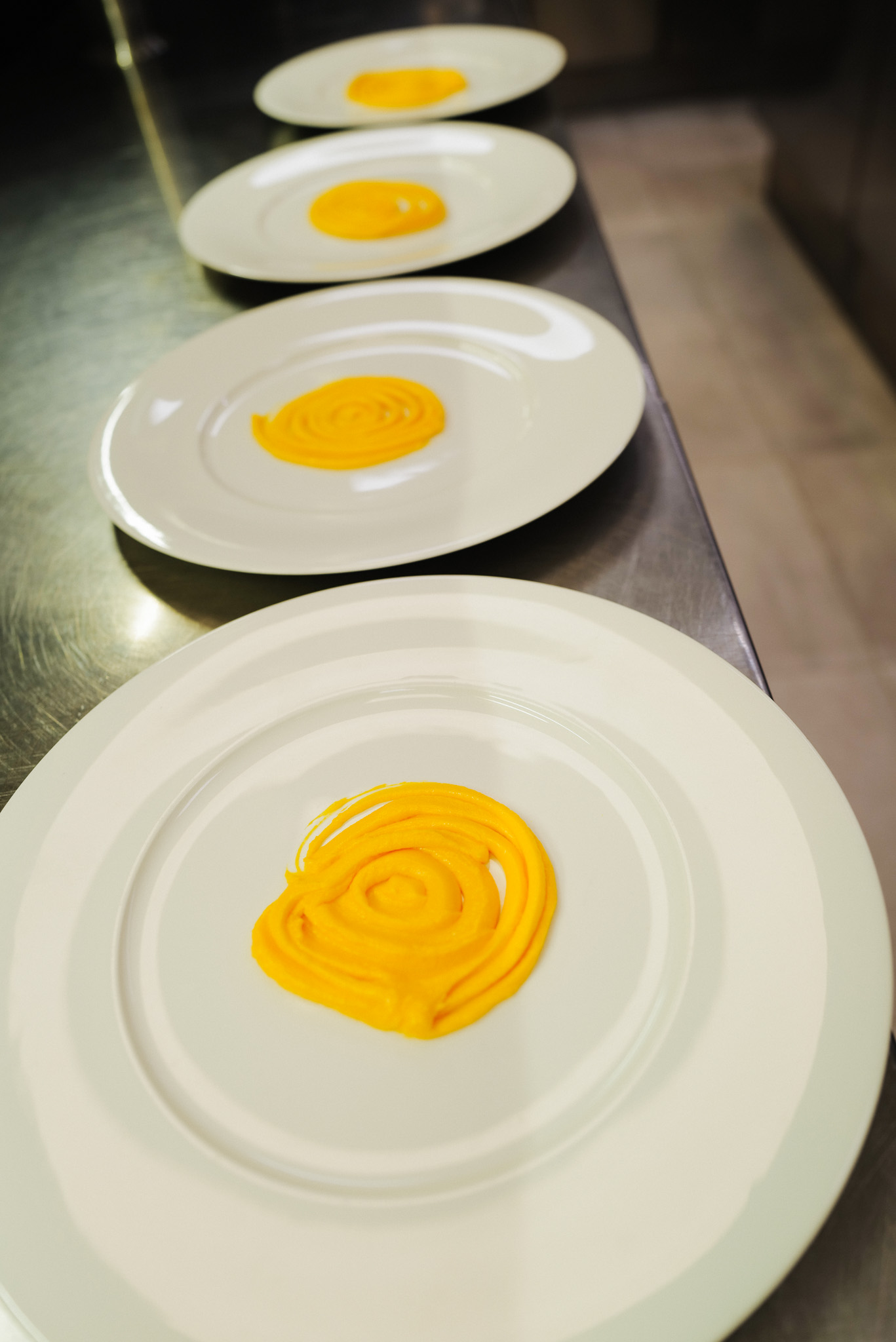 Saffron fondue placed at the bottom of each plate for risotto alla milanese