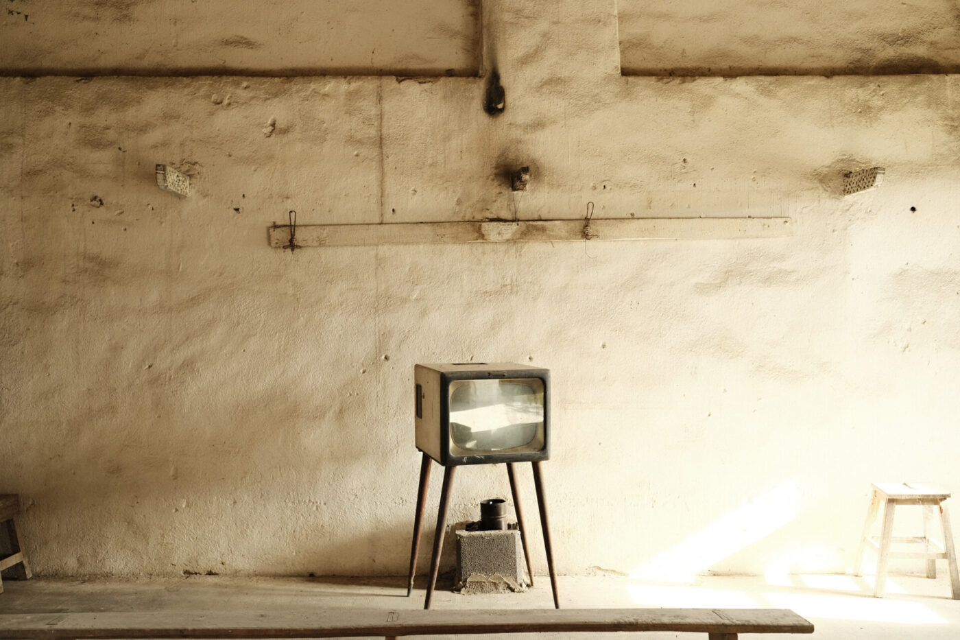 a tiny TV in a large blank room