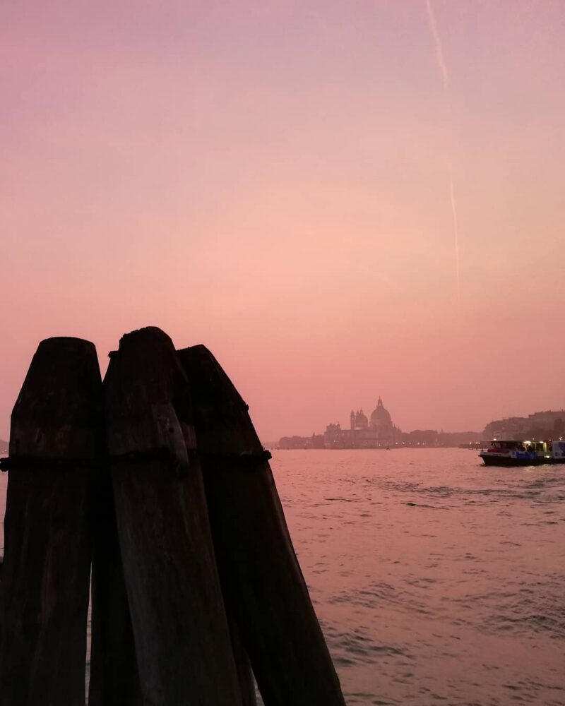 a pink sunset over giudecca island as seen from venice