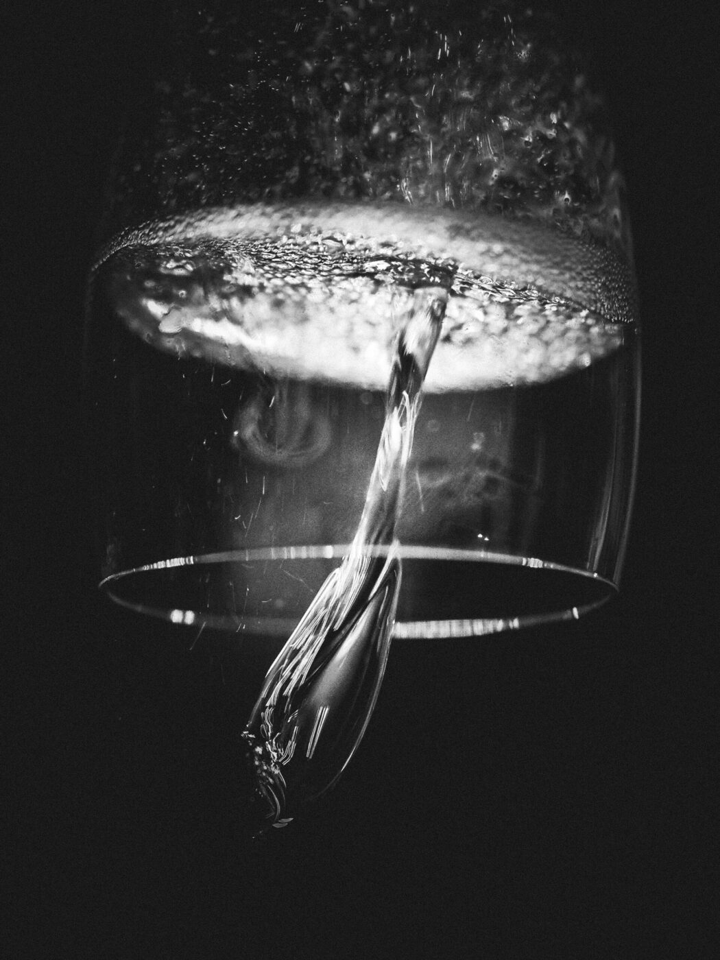 a black and white image of an upside down glass of sparkling wine