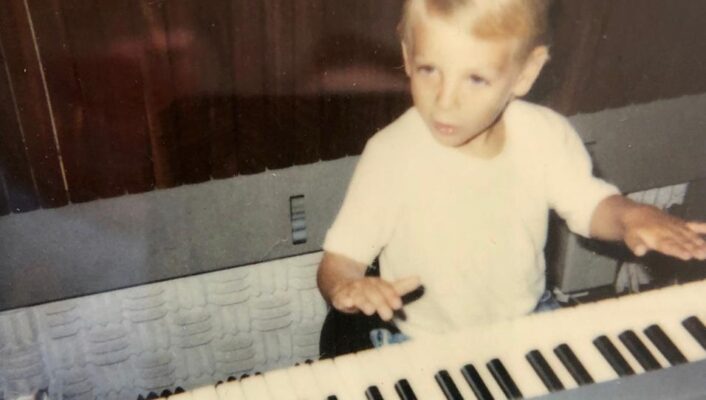 a young axel pani playing music on a keyboard
