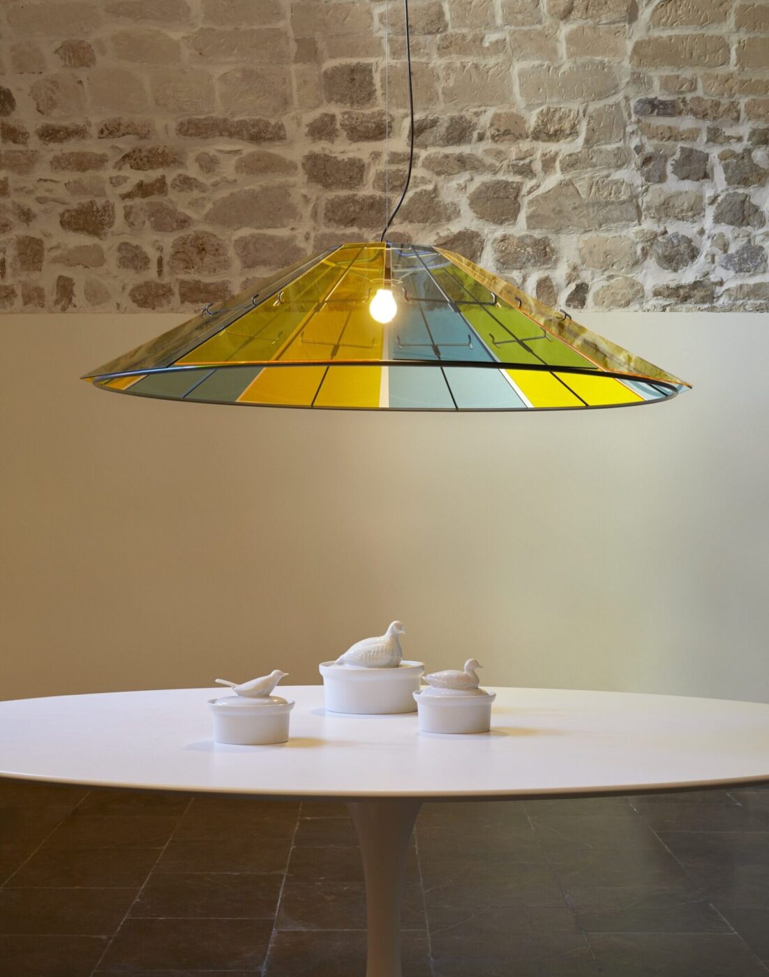 Sure! Following your instruction, here’s an example of how the alt text should be formatted if an image title is present. If the image title is Bird-Themed Breakfast Table, then the alt text should be: Bird-Themed Breakfast Table - A round white table with white ceramic containers shaped like birds sits beneath a large, yellow and green stained glass pendant light, hanging from the ceiling against a stone wall.