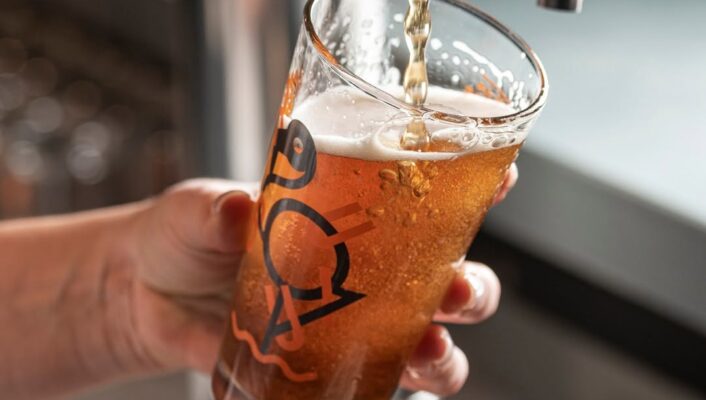 a woman serving a beer
