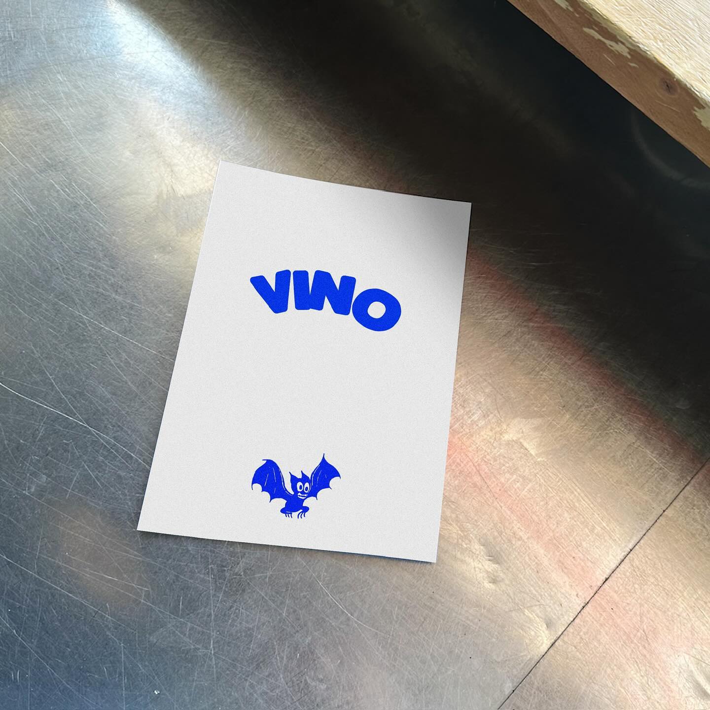 VIVO Card - A white card on a metallic surface displays the word VIVO in bold blue letters and a cartoon blue bat illustration near the bottom.