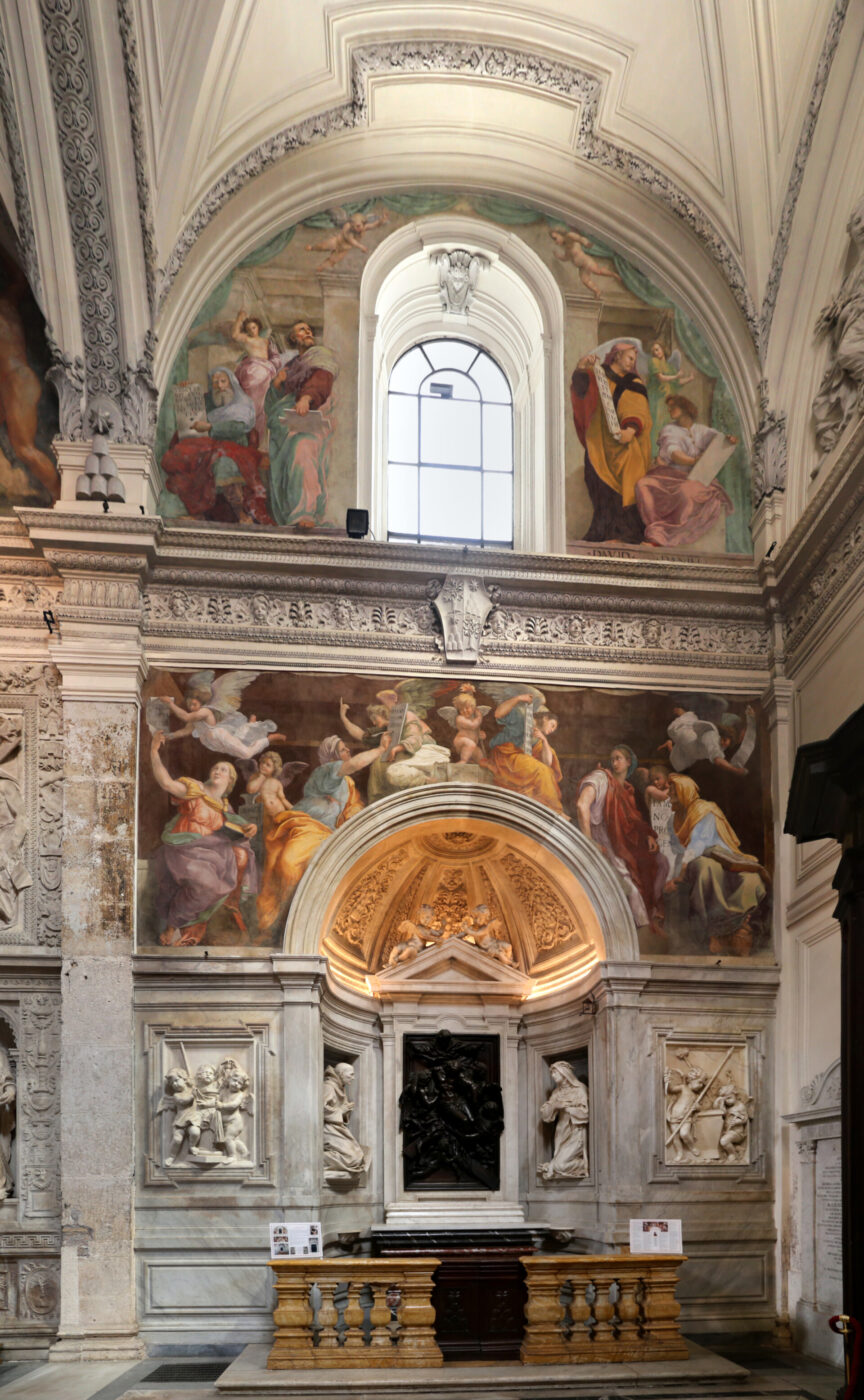 [Nessun titolo dell'immagine fornito] - Veduta dell'interno di una cappella riccamente decorata, con soffitti a volta, sculture in marmo e affreschi colorati raffiguranti figure religiose sopra un altare, illuminata dalla luce naturale proveniente da una finestra ad arco centrale.