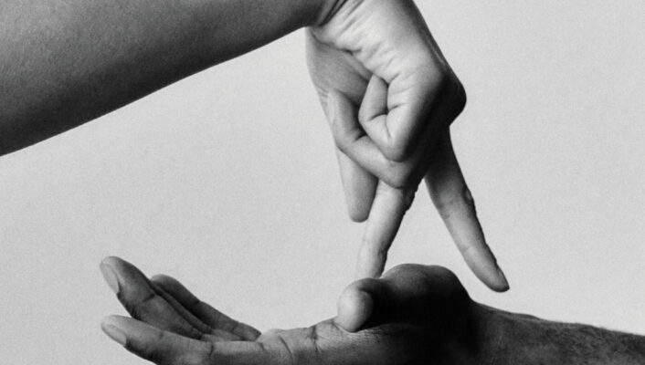 Certamente! Se il titolo dell'immagine, ad esempio, è "Gesto", il testo alt formattato come richiesto sarà: Gesto - Una foto in bianco e nero che mostra una mano tenuta aperta con il palmo verso l'alto e un'altra mano sopra di essa, con le dita rivolte verso il palmo aperto, su uno sfondo semplice.