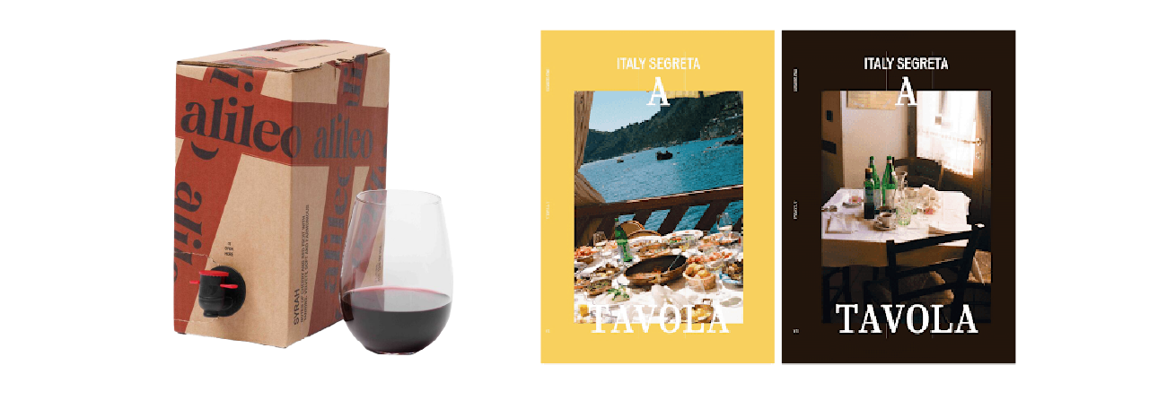 A box of red wine and a filled glass beside two magazines, ITALY SEGRETA and A TAVOLA, showing table settings with food.