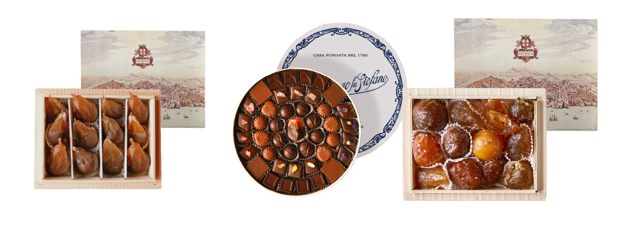 Three boxes of gourmet treats: dried figs, round box of assorted chocolates, and candied chestnuts in front of elegant packaging.