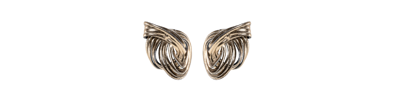 A pair of vintage gold-tone clip-on earrings with an abstract swirl design shown on a plain white background.