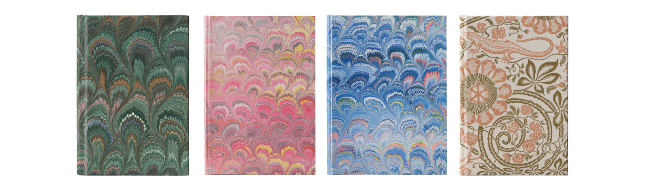 Four decorative notebooks—green, pink, blue marbled, and beige-pink floral—arranged side by side on a white background.