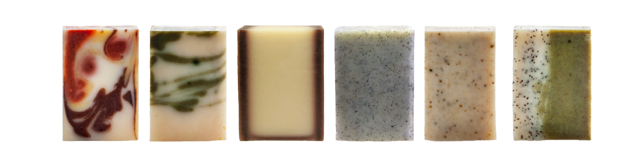 Six distinct handcrafted soap bars with unique colors, swirls, and patterns are lined up on a white background.